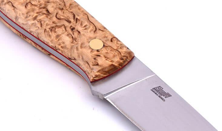 Brisa Trapper 95 mit Griff aus stabilisiertem Maserbirkenholz und flacher Klinge aus N690Co-Stahl mit Bushcraft-Scheide mit Feuerstein